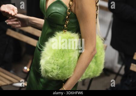 Milano, Italia - 24 settembre 2022: Donna indossa una borsa in lime verde pelliccia sintetica con manico con catena oro, dettagli Street style Foto Stock
