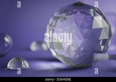 Luce rifrangente a prisma di cristallo, cristalli magici e piramide, sfera e cubo su sfondo viola. Pratica di cristallo di guarigione spirituale. Feng Shui, bravo Foto Stock