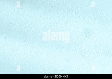 Primo piano della superficie con sapone blu. Schiuma detergente per la cura della pelle consistenza di sapone, schiuma da barba o detergente. Sfondo macro in schiuma con bolle. Lavanderia Foto Stock