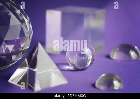 Luce rifrangente a prisma di cristallo, cristalli magici e piramide, sfera e cubo su sfondo viola. Pratica di cristallo di guarigione spirituale. Feng Shui, bravo Foto Stock