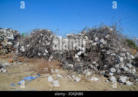Grandi cumuli di tondini aggrovigliati (acciaio di rinforzo) e macerie di calcestruzzo provenienti dai rifiuti di costruzione e demolizione, raccolti per il riciclaggio. Foto Stock