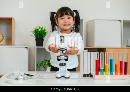 scienziata felice che impara la scienza con un microscopio Foto Stock