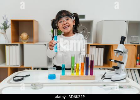 scienziata felice che impara la scienza con il tubo di prova e un bicchiere Foto Stock