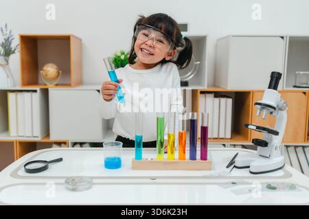 scienziata felice che impara la scienza con il tubo di prova e un bicchiere Foto Stock