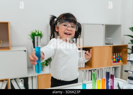 scienziata felice che impara la scienza con il tubo di prova e un bicchiere Foto Stock