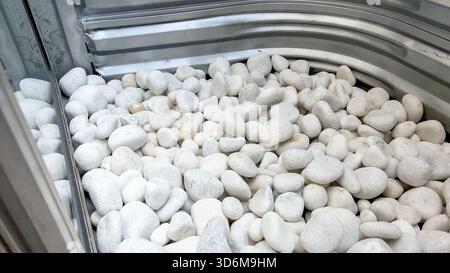 Vista dall'alto delle pietre arrotondate all'interno della finestra metallica Foto Stock