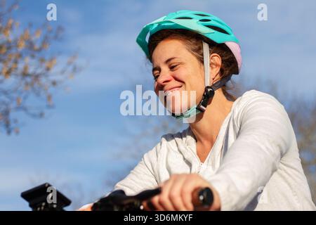 Vera donna che indossa un casco per biciclette all'aperto Foto Stock