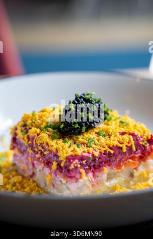 Insalata di aringhe a strati con condimento al caviale Foto Stock
