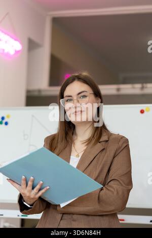 Donna di fronte a una lavagna. Insegnante professionista in classe Foto Stock