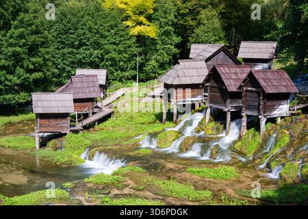 Piccoli mulini ad acqua sui pali del lago Pliva, destinazione turistica vicino a Jajce Foto Stock