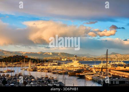 Sunset Harbour di Port Vauban, Antibes con Yachts e Calm Sea Over Boats and Mountains Foto Stock