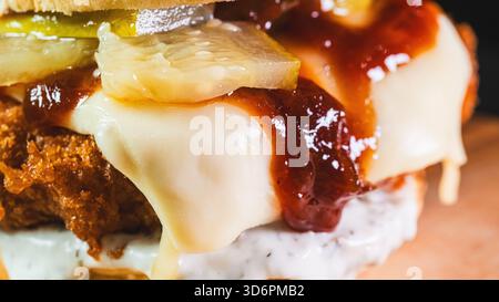 Hamburger katsu di pollo fritto coreano croccante con salsa salata in un panino morbido. Perfetto per la cucina fusion asiatica, le tendenze gastronomiche e le promozioni dei ristoranti. Foto Stock
