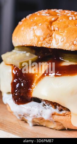 Hamburger katsu di pollo fritto coreano croccante con salsa salata in un panino morbido. Perfetto per la cucina fusion asiatica, le tendenze gastronomiche e le promozioni dei ristoranti. Foto Stock