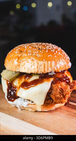 Hamburger katsu di pollo fritto coreano croccante con salsa salata in un panino morbido. Perfetto per la cucina fusion asiatica, le tendenze gastronomiche e le promozioni dei ristoranti. Foto Stock