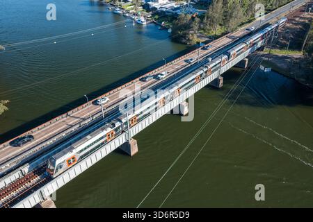 Veduta aerea di un treno interurbano del nuovo Galles del Sud "Mariyung" che attraversa Dora Creek nella regione del Lago Macquarie, NSW, Australia. Foto Stock