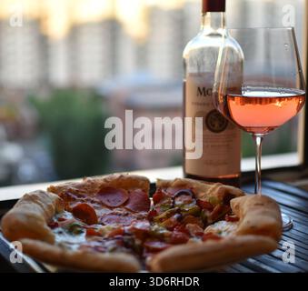 Vino rosato con pizza sullo skyline della città Foto Stock