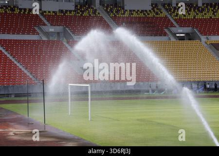 Stadio di calcio vuoto con impianto sprinkler automatico che innaffia il campo di erba verde durante la manutenzione. tranquilla scena di preparazione in un grande professionista Foto Stock