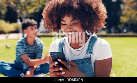 Studentessa universitaria, all'aperto e donna con cellulare, sorriso e social media con meme divertenti. Campus, college e persona con comunicazione, ridendo Foto Stock