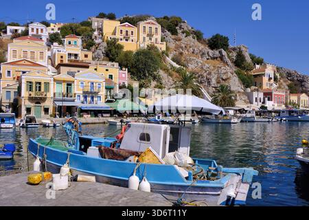 Symi: Porto con barche da pesca, yacht e case tradizionali colorate a Symi, Grecia Foto Stock