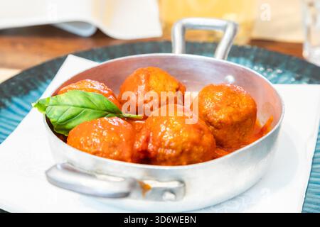 Polpette tradizionali servite con foglie di basilico e salsa di pomodoro. Ristorante Italiano - chiamato Osteria - a Torino, nel nord dell'Italia. Foto Stock
