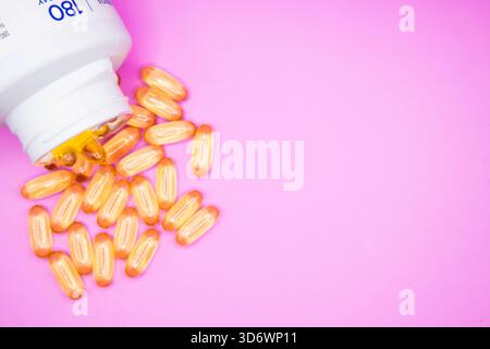 Compresse di olio di fegato di merluzzo che fuoriescono da un contenitore aperto, adatto per salute, nutrizione, e temi integrativi. Foto Stock