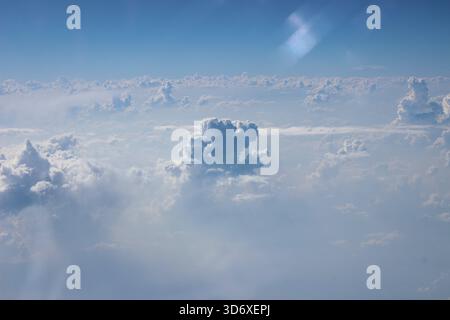 Questa fotografia cattura le nuvole lussureggianti visibili dall'aereo. Il cielo è permeato di luce, rendendo ogni contorno delle nuvole particolarmente ex Foto Stock