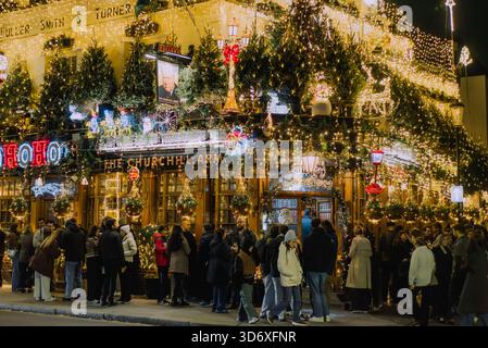 Il pub Churchill Arms decorato con luci di Natale a Londra di notte, 11/17/2025 Foto Stock
