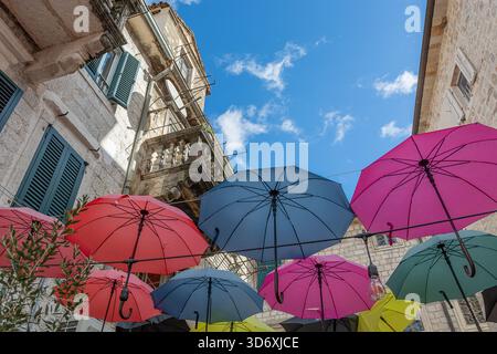 Un colorato ombrello all'esterno di una caffetteria nella città vecchia di Cattaro, che annuncia la stagione delle piogge che arriva a novembre Foto Stock