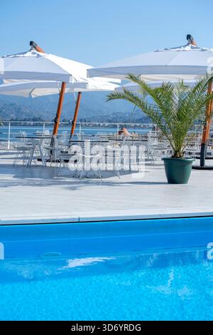 Tavolo e sedie con ombrellone in una caffetteria sulla spiaggia vicino al mare a Batumi, Georgia. Batumi è una delle destinazioni turistiche più visitate in Foto Stock