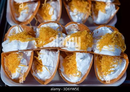Deliziosa strada Thai dessert, Kanom Buang, Tailandese frittelle croccanti o Thai crêpe con varietà di farciture come bianco e dolce crema pasticcera e golden Foto Stock