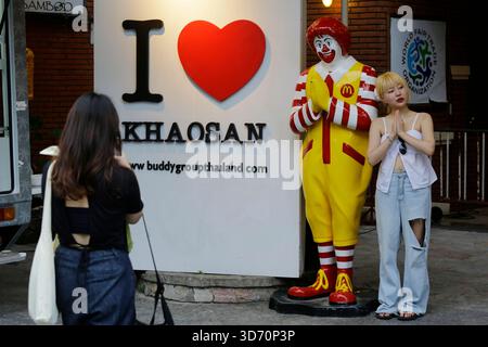 Bangkok, Thailandia - 22 luglio 2022: I turisti posano per le foto accanto a un manichino Ronald McDonald che gestiva un Wai, o Namaste, al McDonald's.. Foto Stock