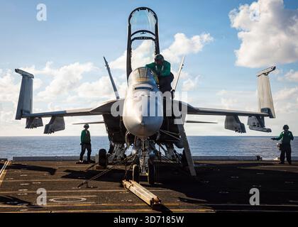 I marinai statunitensi effettuano controlli pre-volo su un aereo F/A-18F Super Hornet sul ponte di volo della più grande portaerei del mondo, l'aircr di classe Ford Foto Stock
