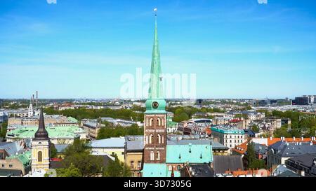 Panorama in droni dello storico skyline di riga con la guglia della cattedrale di San Giacomo nella capitale della Lettonia che si innalza contro un cielo azzurro, catturando la luce estiva a. Foto Stock