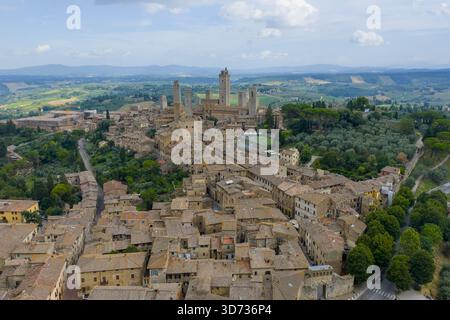 Veduta aerea delle torri medievali in pietra di San Gimignano e del centro storico fortificato, ex centro commerciale della via Francigena in Toscana. Foto Stock