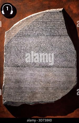Primo piano dell'iscrizione in pietra di Rosetta esposta in una mostra Tutankhamon, che mostra una dettagliata scrittura trilingue utilizzata per decifrare l'antico egizio Foto Stock