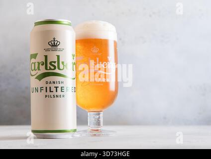 LONDRA, Regno Unito - 11 NOVEMBRE 2025: Birra lager non filtrata Carlsberg in latta di alluminio e vetro originale su un tavolo leggero. Foto Stock