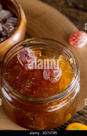 marmellata a base di arance e agrumi freschi e essiccata con sciroppo di zucchero, frutta kumquat intera in polvere bianca, vaso di vetro con marmellata di arancia dolce sul Foto Stock