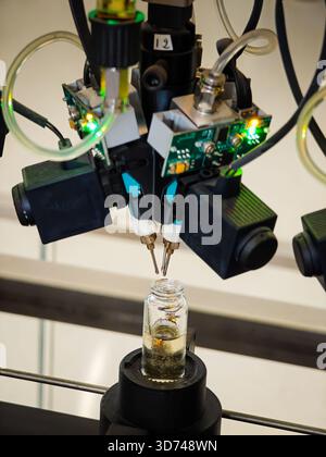 Produzione di profumi. Profumi diversi in bottiglia. Linea di produzione robotizzata di profumi con erogazione automatica di fragranze Foto Stock