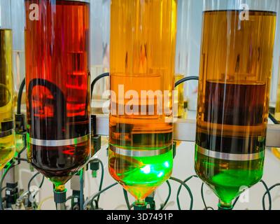 Produzione di profumi. Profumi diversi in bottiglia. Linea di produzione robotizzata di profumi con erogazione automatica di fragranze Foto Stock