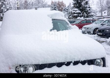 Rimozione della neve da un'auto in inverno. Un'auto sepolta nella neve, non preparata per la guida. Foto Stock
