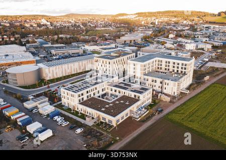 Veduta aerea di un panorama cittadino con edifici moderni e campi adiacenti, nuovo ospedale, campus salute Calw, Foresta Nera, Germania Foto Stock