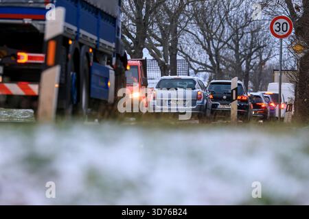 Lipsia, Germania. 24 novembre 2025. Le auto si accumulano su una strada arteria nella parte occidentale di Lipsia dopo la nevicata di notte. Secondo il servizio meteorologico tedesco, un sistema a bassa pressione sta portando in Germania un'ondata di aria leggera dell'Atlantico. La neve non rimarrà, invece il tempo sarà instabile, freddo e umido. Crediti: Jan Woitas/dpa/Alamy Live News Foto Stock