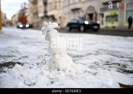 Lipsia, Germania. 24 novembre 2025. Un piccolo pupazzo di neve si trova accanto a una strada nella parte occidentale di Lipsia. Secondo il servizio meteorologico tedesco, le temperature aumenteranno fino a 4 gradi nei prossimi giorni. Crediti: Jennifer Brückner/dpa/Alamy Live News Foto Stock
