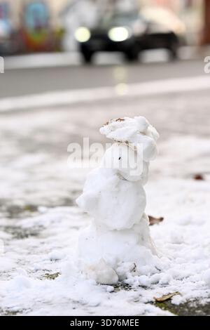 Lipsia, Germania. 24 novembre 2025. Un piccolo pupazzo di neve si trova accanto a una strada nella parte occidentale di Lipsia. Secondo il servizio meteorologico tedesco, le temperature aumenteranno fino a 4 gradi nei prossimi giorni. Crediti: Jennifer Brückner/dpa/Alamy Live News Foto Stock