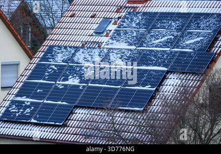 Lipsia, Germania. 24 novembre 2025. Un sottile strato di neve copre il sistema solare in una casa indipendente. Le condizioni invernali possono influenzare temporaneamente le prestazioni dei sistemi di energia solare. Crediti: Jan Woitas/dpa/Alamy Live News Foto Stock