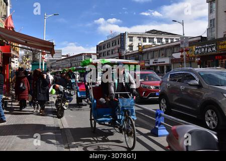 15 gennaio 2021 - Lhasa, Tibet: Una strada trafficata con auto e risciò nel centro di Lhasa. Foto Stock