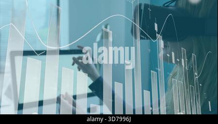Analisi di un analista che indossa un blazer che tocca un tablet alla scrivania, con sovrapposizione di grafici finanziari e cuffie Foto Stock