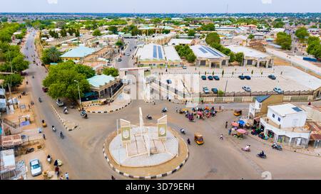 Vista aerea della vivace rotatoria e degli edifici con pannelli solari crogiolati sotto il sole, M Dikko Road, Katsina, Katsina, Nigeria. Foto Stock