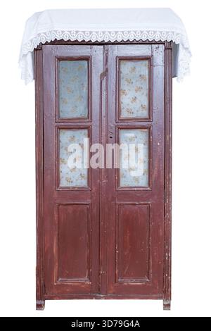 Armadio antico in legno con pannelli in vetro e tessuto decorativo sulla parte superiore con sfondo bianco Foto Stock