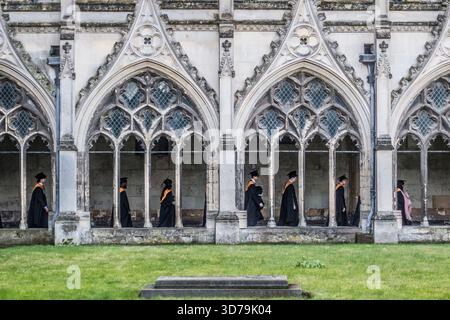 Gli studenti dell'Università del Kent si recano nei chiostri della cattedrale di Canterbury per la cerimonia di laurea alla fine di novembre (Kent, Regno Unito). Tradizionalmente indossano abiti, cappellini o mensa accademica Foto Stock